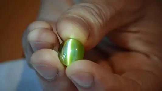 Gloeiende groene "Cat's eye" in de hand