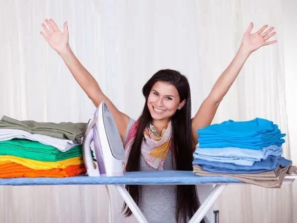 The girl ironed the clothes and is happy