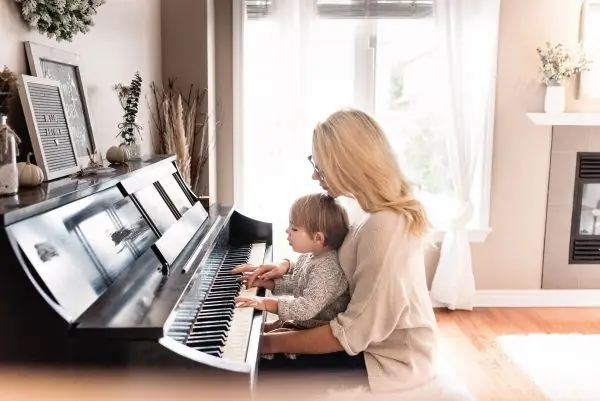 Babae na may anak sa piano