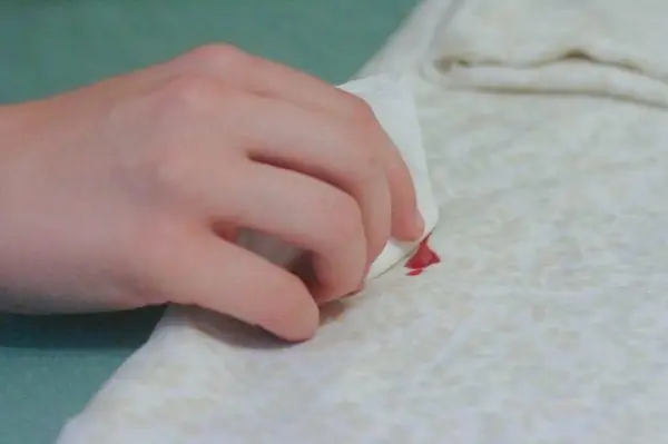 Removing a red nail polish stain from a white fabric