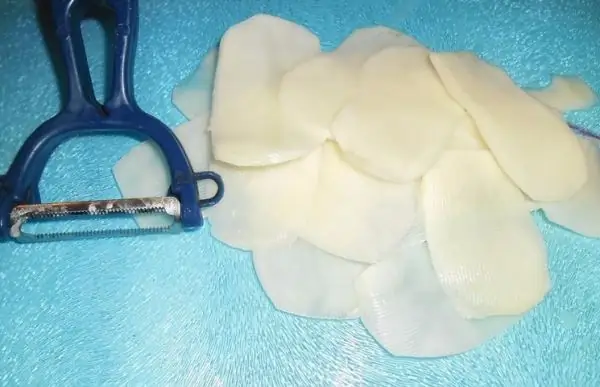 slicing potatoes with a peeler